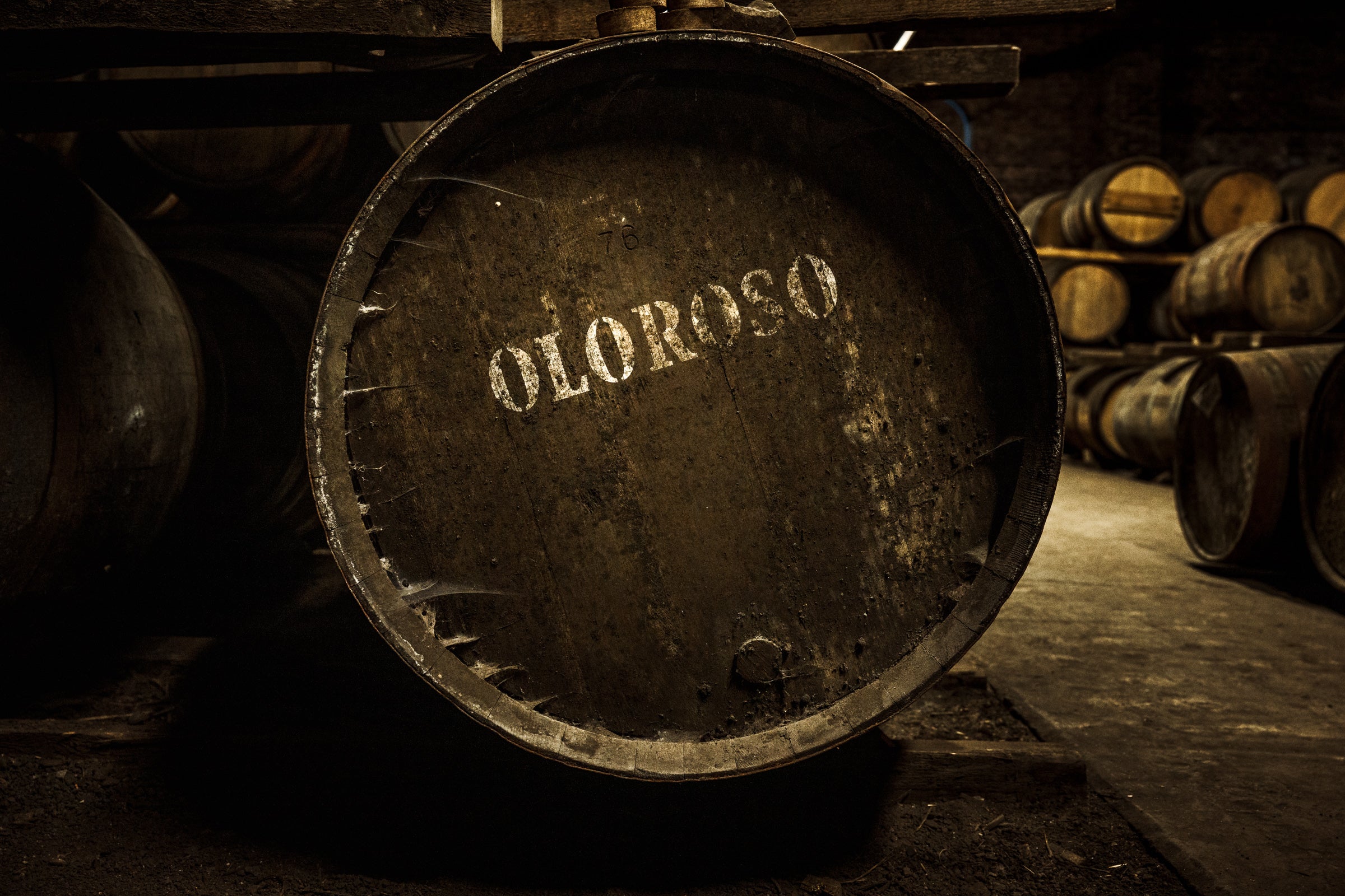 A wooden cask labelled 'Oloroso', surrounded by other casks in a warehouse